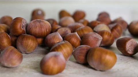 Throwing unpeeled hazelnuts on the table. slow motion Video stock 140130507
