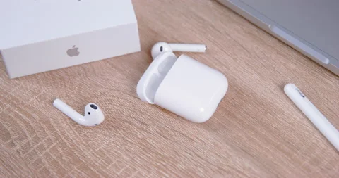 Thrown wireless Airpods fall onto light table near open case Video stock 221878271