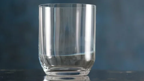 Throws ice cubes in a glass cup. Cold whiskey. Stock Footage 130742058