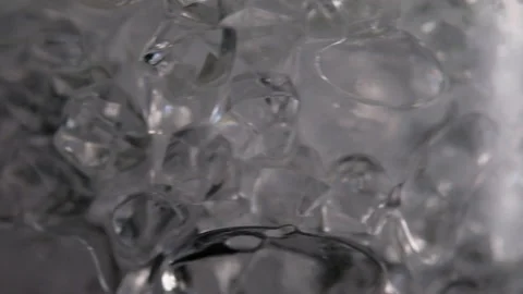 Throws ice cubes in a glass cup. Cold whiskey. Slow motion. Stock Footage 130742683