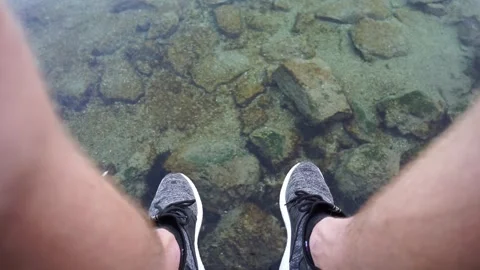 Throws stones into the water. Video stock 243748781