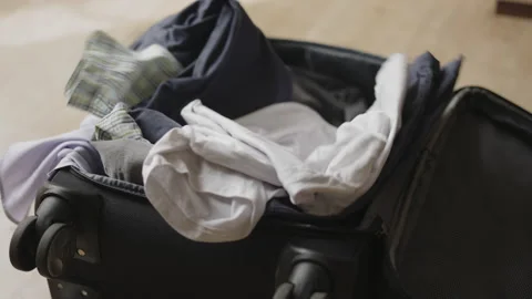 Throws things in a suitcase. He is in a hurry to pack his luggage. Late for a Stock Footage 239933311
