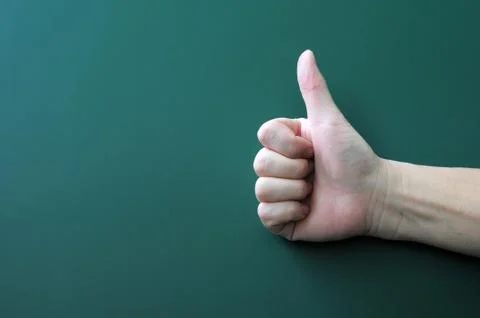 Thumb up on a blackboard background Stock Photos