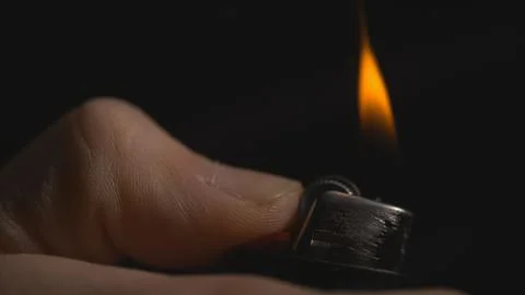 Thumb igniting lighter side view Stock Photos