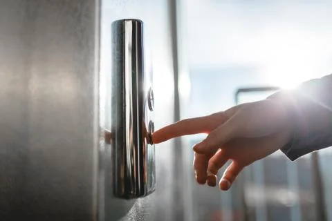 The thumb presses the Elevator button, a hand reaching for the button, the gi Fotos de archivo
