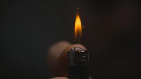 Thumb pressing lighter macro Stock Photos