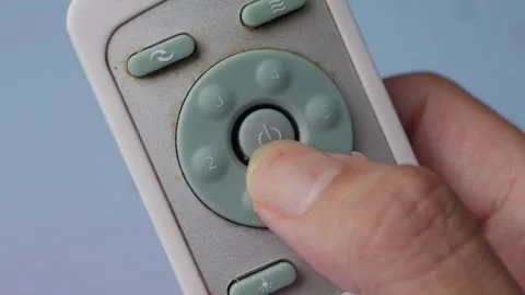 Thumb Pressing The Power Button On A Portable Remote Control For Ceiling Stock Footage 288421527
