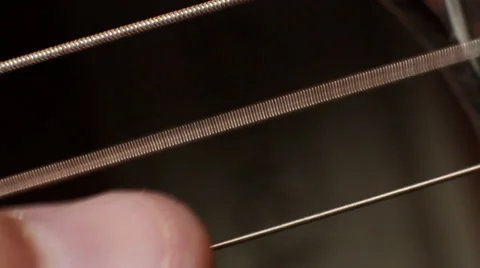 Thumb strike the string on the guitar, guitar soundboard, closeup Видео 32226417