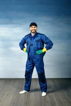 Thumb up. Young handsome man with a beard in a blue working uniform for clean Stock Photos