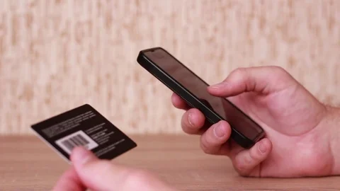 Thumbing through the smart phone and holding plastic card Vídeos de archivo 83533964