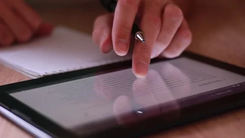 Thumbing through the tablet and writing Vídeo Stock 83747660