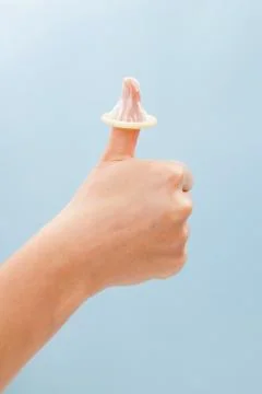 Thumbs up with condom on thumb. Stock Photos