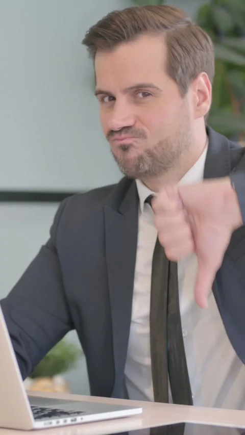 Thumbs Down by Businessman Working on Laptop, vertical video 動画素材 328557868