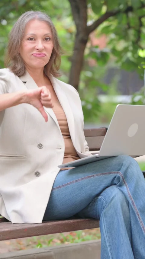 Thumbs Down by Old Woman Using Laptop Outdoor on Bench Vídeo Stock 319968351
