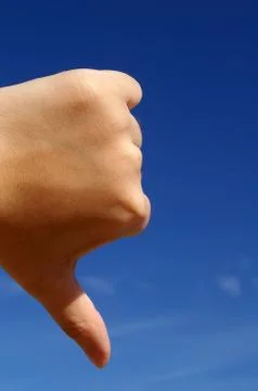 Thumbs down under blue sky Stock Photos