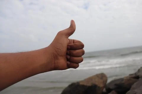 Thumbs Up Hand Gesture Emerging from Ocean Water Stock Photos