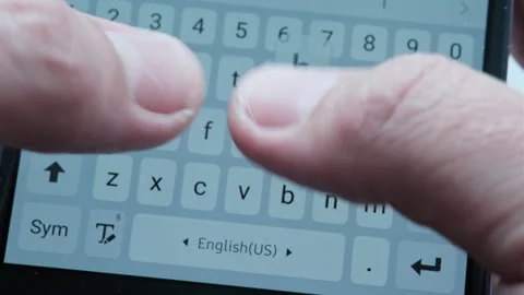 Thumbs of hand type letters and words of messages on Internet on mobile phone. C Stockbeeldmateriaal 247177020