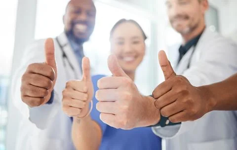 Thumbs up, hands and doctors with nurses in clinic for agreement on medical.. Stock Photos