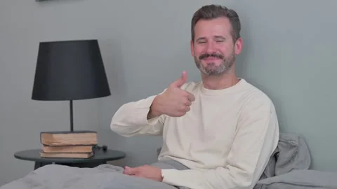 Thumbs Up by Middle Aged Man in Bed Stock Footage 287899181