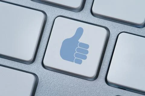 Thumbs up or like symbol at the computer keyboard Stock Photos