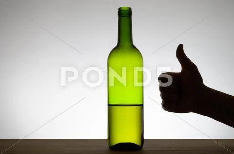Thumbs up sign and a bottle of wine Stock Photos