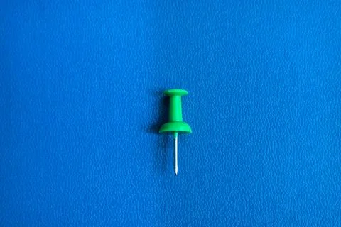 A thumbtack on a blue background Stock Photos