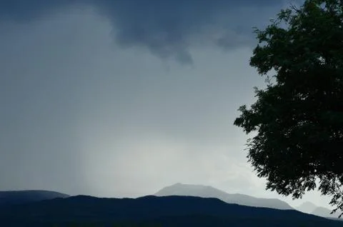 Thunder and rain clouds over mountain and field in summer Stock Photos