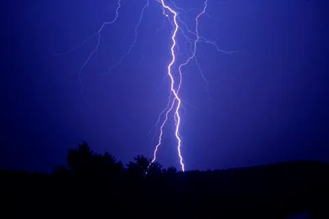Thunder storm, lightning hits a hill Stock Photos