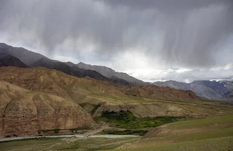 Thundercloud and heavy rain over the mountains and river valley. Stock Photos