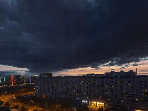 Thundercloud and setting sun in a big city Stock Photos