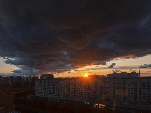 Thundercloud and setting sun in a big city Stock Photos