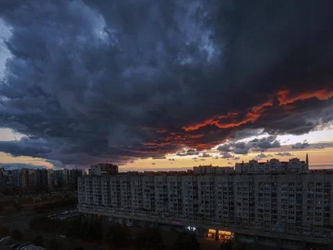 Thundercloud and setting sun in a big city Stock Photos