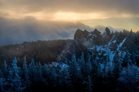 A thundercloud moving over the crest of a snow covered cliff Stock Photos