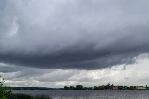 Thundercloud over river. Big dark clouds. Stormy weather. Stock Photos