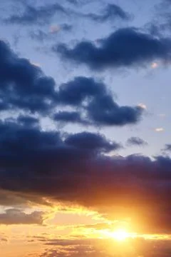 Thunderclouds with breaking rays sun at sunset. Stock Photos