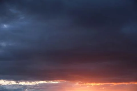 Thunderclouds with breaking rays sun at sunset. Stock Photos