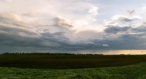 Thunderclouds over an arable field in the countryside. Evening time. A farm, Stock Photos