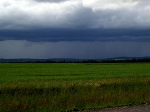 Thunderclouds over field Stock Photos