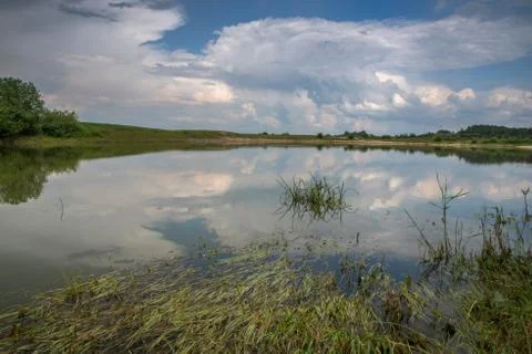 Thunderclouds over the lake. Reflection of the sky in the water. 写真素材