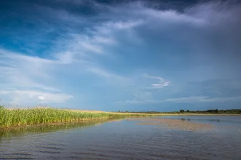 Thunderclouds over the lake. Reflection of the sky in the water. Stockfoto's