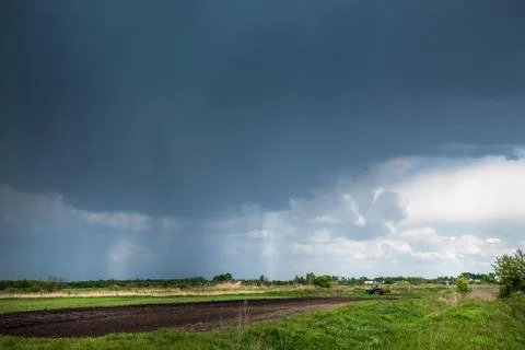 Thunderclouds over meadows and fields. The sun and jets of rain in the sky. 写真素材