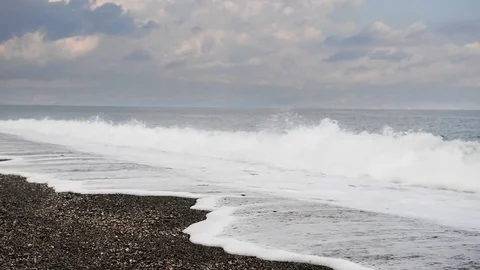 Thundering waves fell on the beach on a variable day in summer Stock Footage 83222052