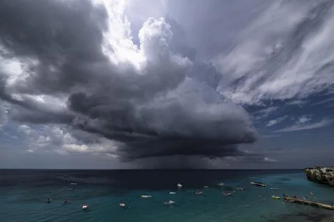 Thundershower scenery with flying clouds over the turquoise sea around Curacao Stock Photos