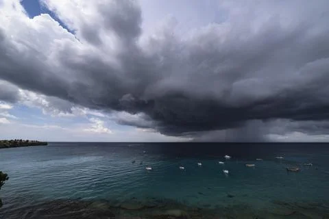 Thundershower scenery with flying clouds over the turquoise sea around Curacao Stock Photos