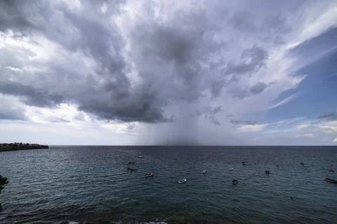 Thundershower scenery with flying clouds over the turquoise sea around Curacao Stock Photos