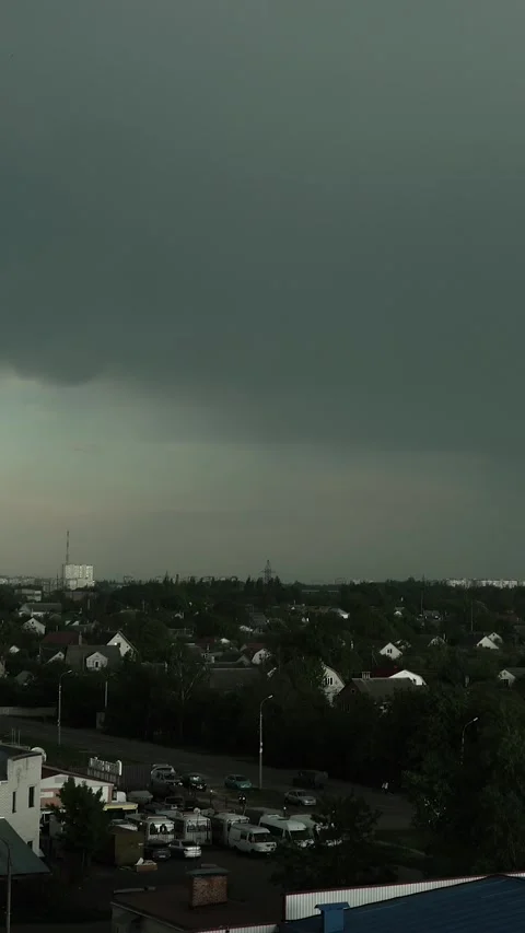 A thunderstorm and rain in a city with dark gray clouds in the sky Stock Footage 335378063