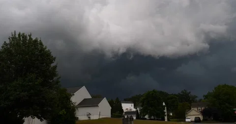 Thunderstorm clouds dark and thick above neighborhood of houses wide Stock Footage 207929191