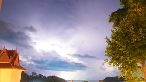 Thunderstorm clouds illuminated by lightning over tropical landscape Foto stock