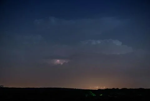 Thunderstorm clouds at night with lightning Stock Photos