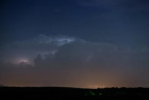 Thunderstorm clouds at night with lightning Stock Photos